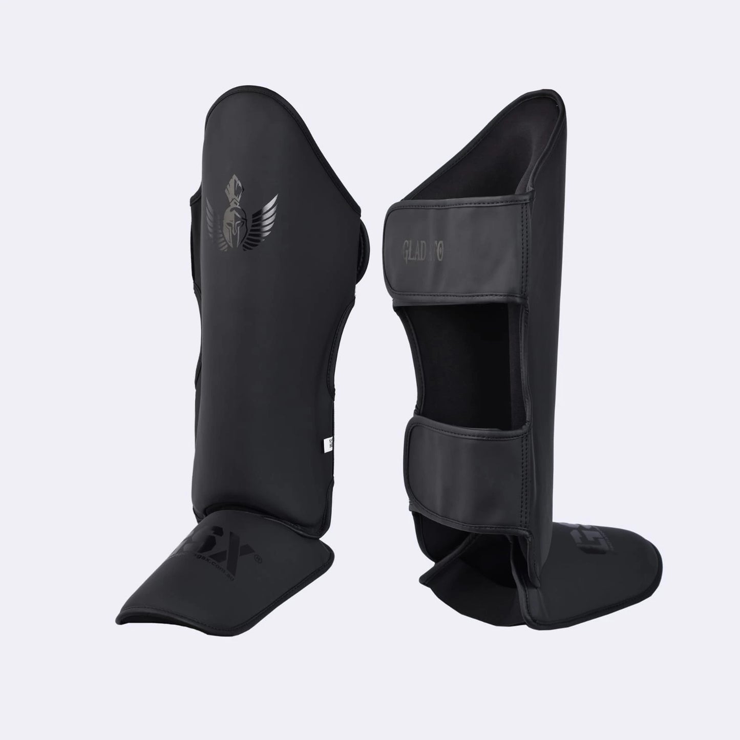 Pair of black GSX Gladiator martial arts shin guards with a Spartan helmet logo, shown from the front and back.