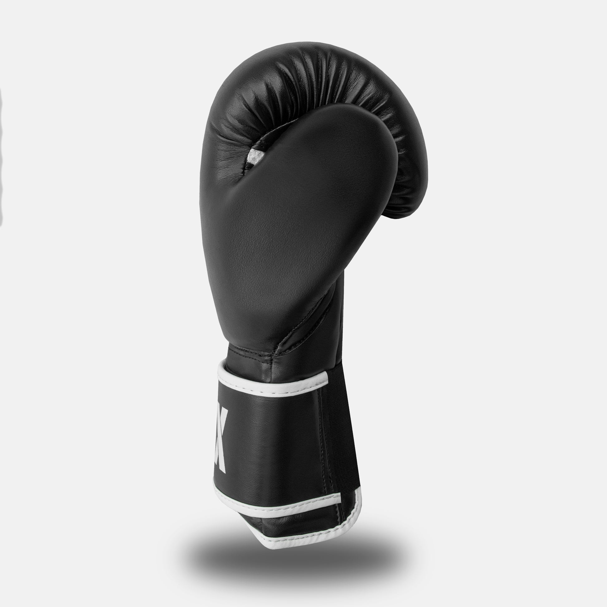Side view of a white-on-black GSX boxing glove showing the curved padding and wrist strap design.
